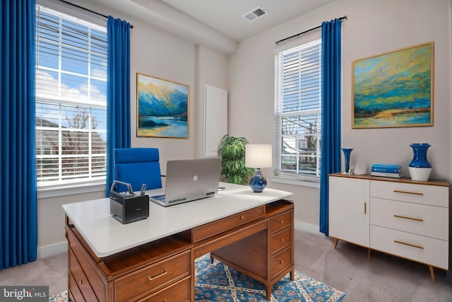 office space with light carpet, visible vents, and baseboards