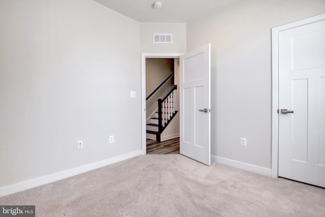 unfurnished bedroom with carpet, visible vents, and baseboards