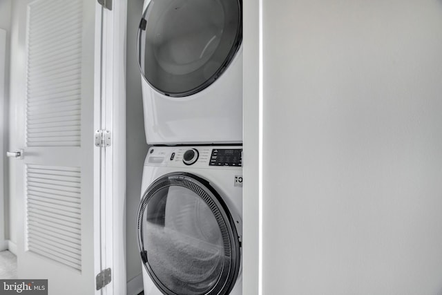 laundry area with stacked washer / drying machine and laundry area