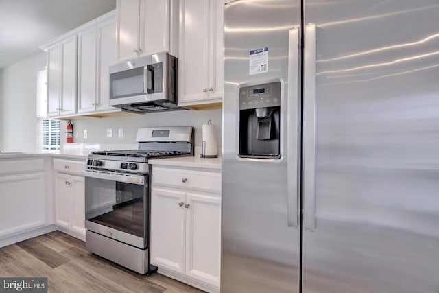 kitchen featuring white cabinetry, appliances with stainless steel finishes, light countertops, and light wood finished floors