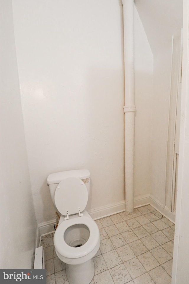 bathroom featuring baseboards and toilet