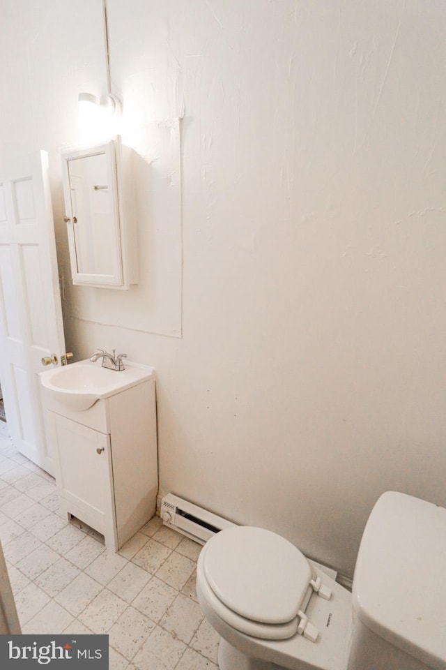 bathroom with toilet, baseboard heating, and vanity