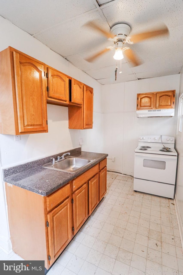 kitchen featuring electric stove, light floors, dark countertops, a sink, and under cabinet range hood