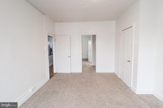 unfurnished bedroom with carpet floors and baseboards