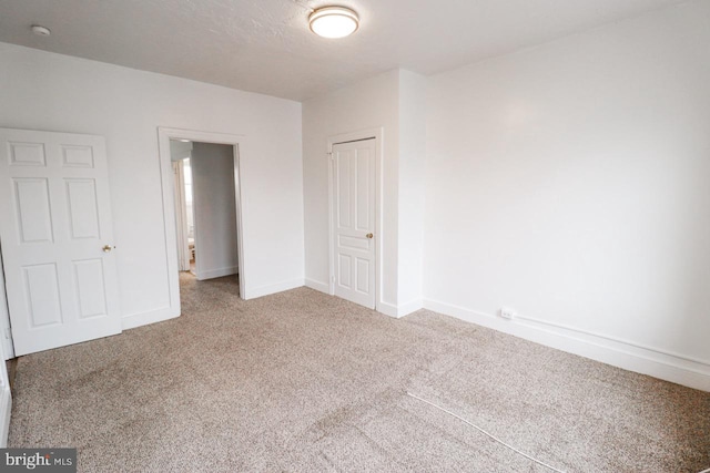 unfurnished bedroom featuring carpet floors, a closet, and baseboards