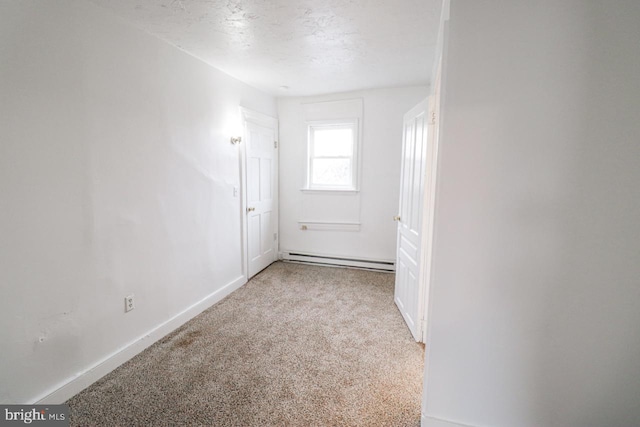 empty room featuring carpet floors, a baseboard radiator, a textured ceiling, and baseboards