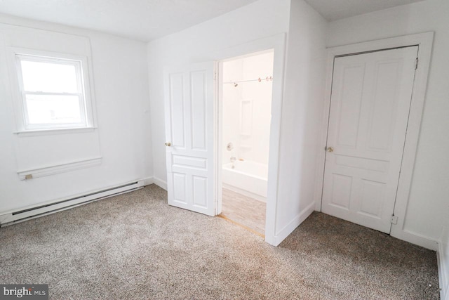 unfurnished bedroom with ensuite bath, baseboards, baseboard heating, and carpet flooring