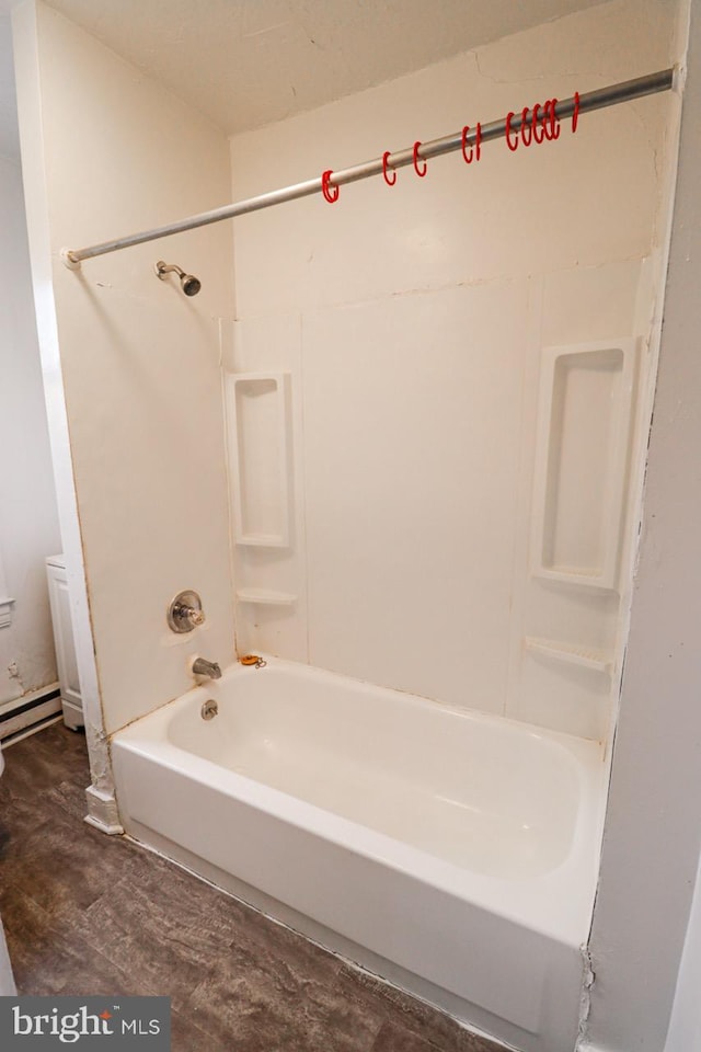 bathroom featuring a baseboard radiator, tub / shower combination, and toilet