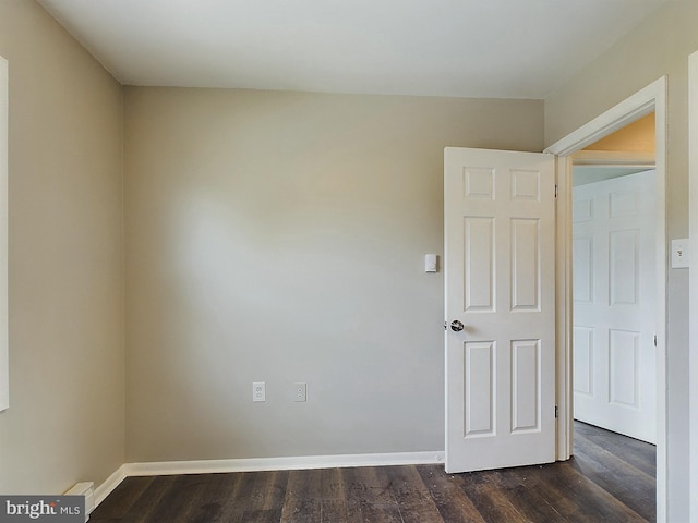 unfurnished room with dark wood finished floors and baseboards