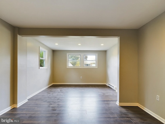 spare room with baseboard heating, recessed lighting, dark wood finished floors, and baseboards