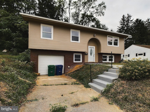 bi-level home featuring an attached garage and brick siding