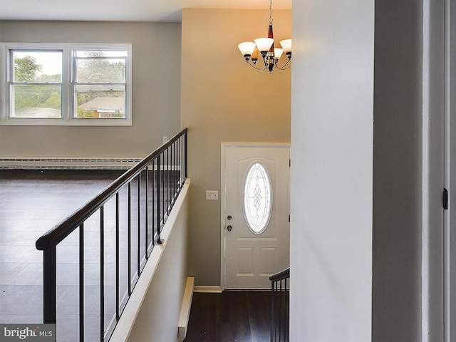 entryway with stairs, baseboard heating, wood finished floors, and a notable chandelier