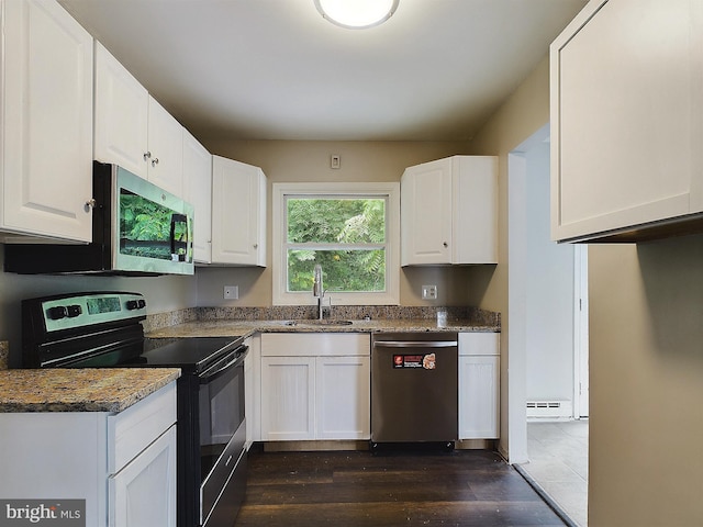 kitchen featuring a baseboard heating unit, stainless steel appliances, a sink, and white cabinets