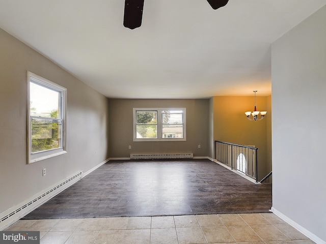 unfurnished room with baseboards, a baseboard radiator, tile patterned floors, an inviting chandelier, and a baseboard heating unit