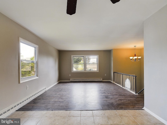 unfurnished room with a baseboard heating unit, a baseboard radiator, a chandelier, and a wealth of natural light