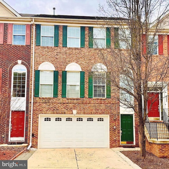 multi unit property with a garage, concrete driveway, and brick siding