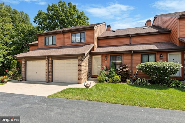 view of property with an attached garage, a shingled roof, driveway, a chimney, and a front yard