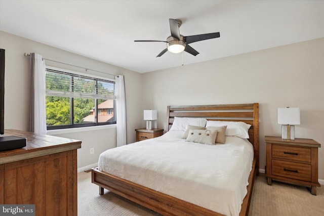 bedroom featuring light colored carpet, a ceiling fan, and baseboards