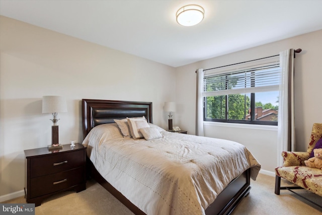 bedroom with light carpet and baseboards