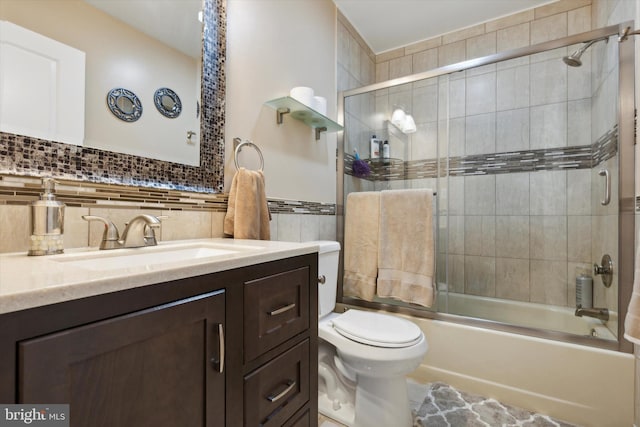 bathroom featuring tasteful backsplash, toilet, enclosed tub / shower combo, vanity, and tile walls