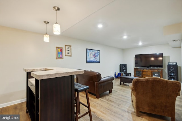 living area with recessed lighting, baseboards, and light wood finished floors