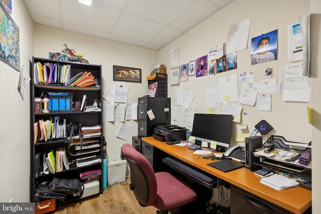 office area with a drop ceiling and wood finished floors