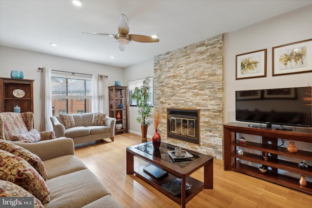 living room with light wood finished floors, baseboards, a ceiling fan, a fireplace, and recessed lighting