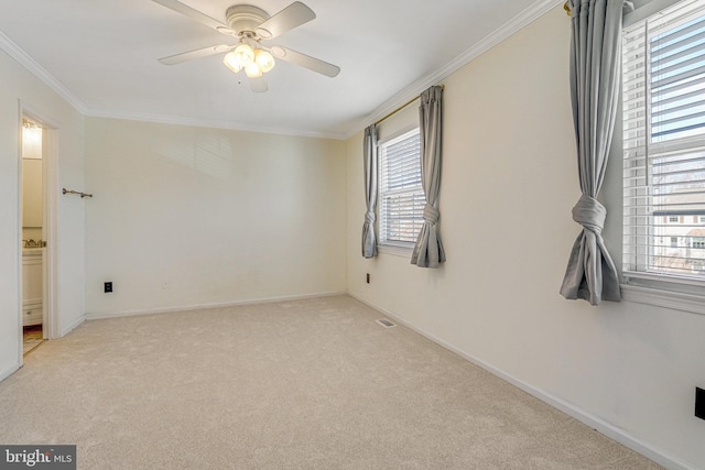 unfurnished room featuring baseboards, light colored carpet, a healthy amount of sunlight, and ornamental molding