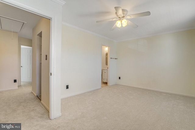 spare room with attic access, crown molding, and light carpet