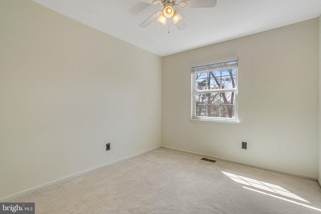 carpeted spare room featuring visible vents, ceiling fan, and baseboards