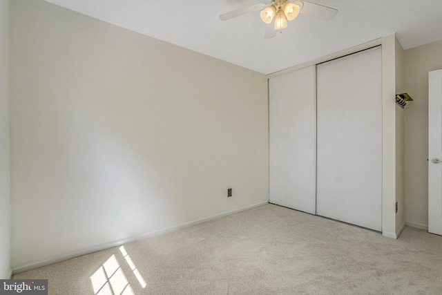 unfurnished bedroom featuring a closet, carpet floors, baseboards, and ceiling fan