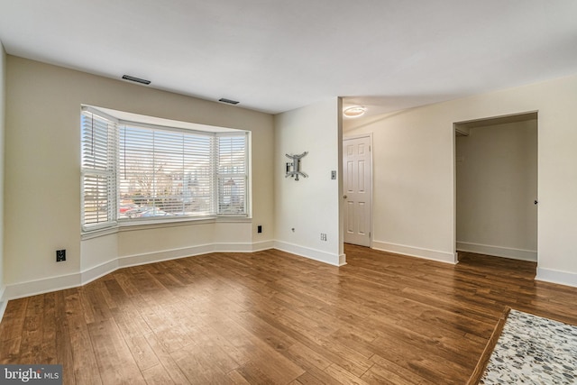 unfurnished room with baseboards and wood finished floors