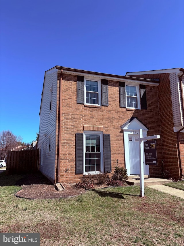 view of front facade featuring brick siding and a front yard