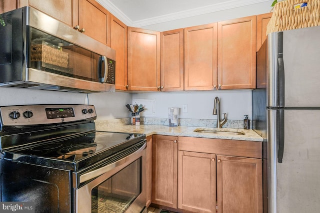 kitchen featuring appliances with stainless steel finishes, light stone countertops, a sink, and ornamental molding