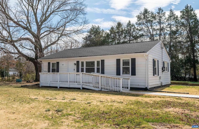 single story home with a front yard and a wooden deck