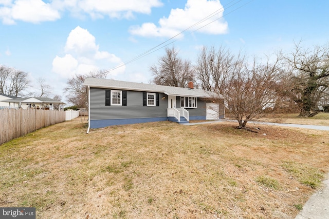 view of front facade featuring a garage, a chimney, fence, and a front yard