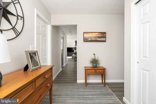 corridor featuring dark wood-style floors and baseboards