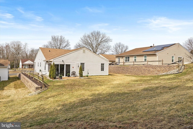 rear view of property with a yard and fence