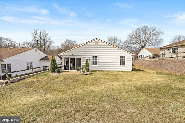 rear view of property with a lawn, a patio, and fence