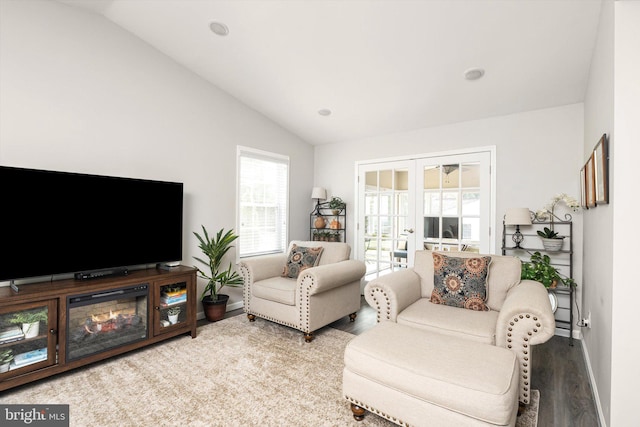 living area with lofted ceiling, wood finished floors, french doors, and baseboards