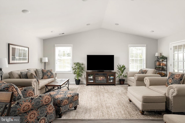 living room with baseboards, lofted ceiling, and carpet