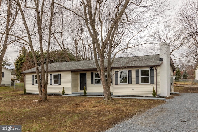 single story home with roof with shingles and a chimney