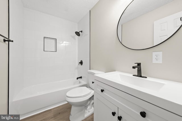 full bath featuring toilet, wood finished floors, bathtub / shower combination, a textured ceiling, and vanity