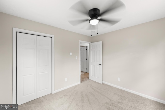 unfurnished bedroom featuring a closet, carpet, a ceiling fan, and baseboards