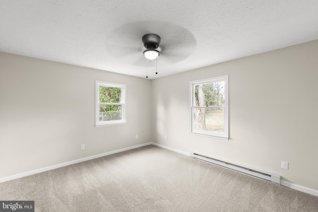 carpeted empty room with plenty of natural light, baseboards, baseboard heating, and a textured ceiling