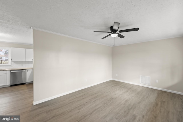 unfurnished room featuring light wood finished floors, visible vents, a ceiling fan, ornamental molding, and baseboards