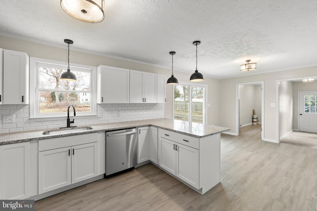 kitchen featuring a peninsula, a sink, white cabinetry, dishwasher, and light wood finished floors