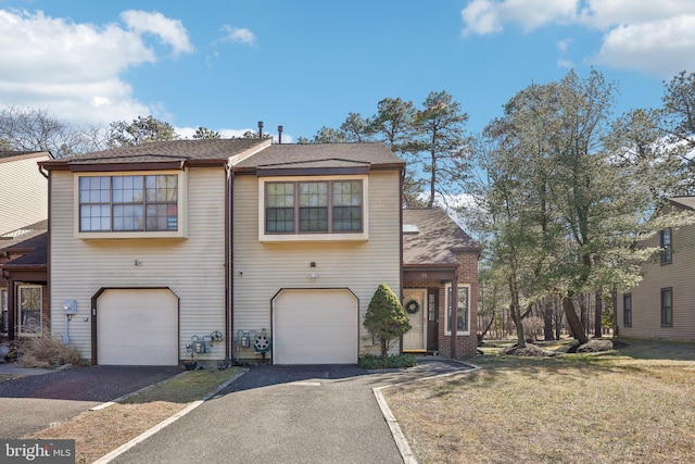 view of front facade with a front yard, driveway, and an attached garage