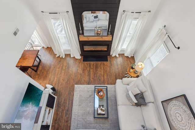 living area featuring visible vents, a fireplace, and wood finished floors