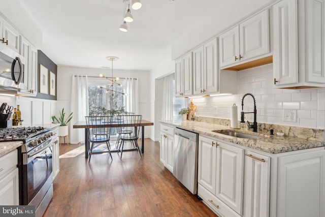 kitchen featuring dark wood finished floors, white cabinetry, stainless steel appliances, and a sink